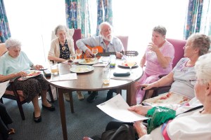 Singer with guitar entertaining pensioners