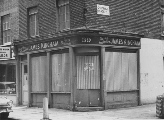 Boarded up shop on street corner.
