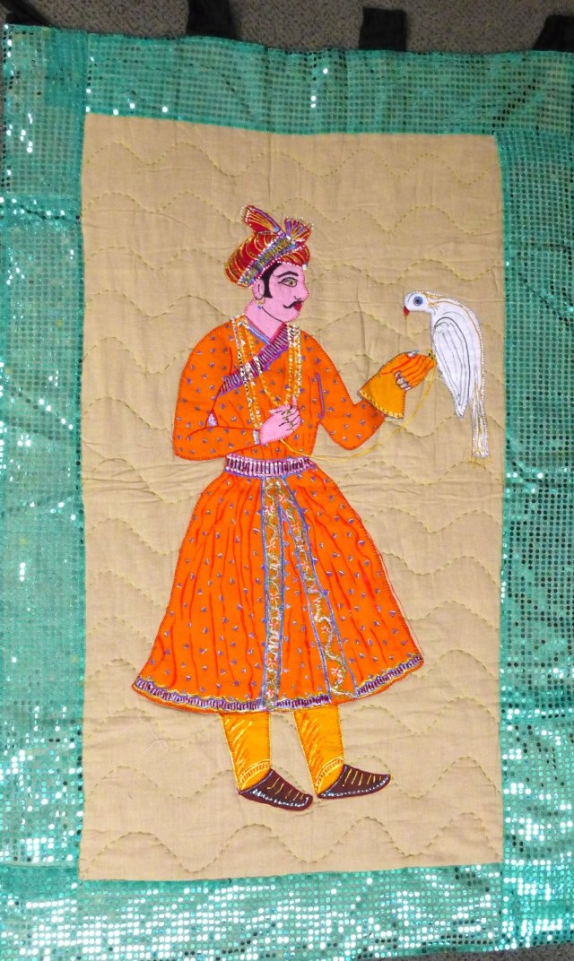 Handmade quilt showing illustrating man holding bird.