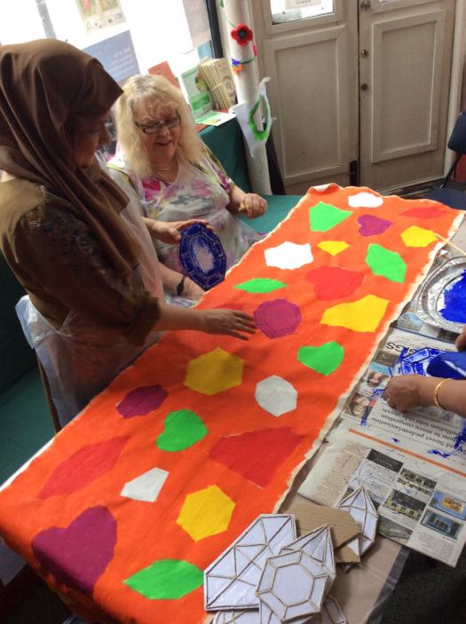 Women creating panel for art installation.